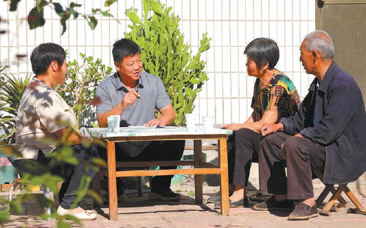 张建设（左二）在自家院子里为村民调解矛盾。